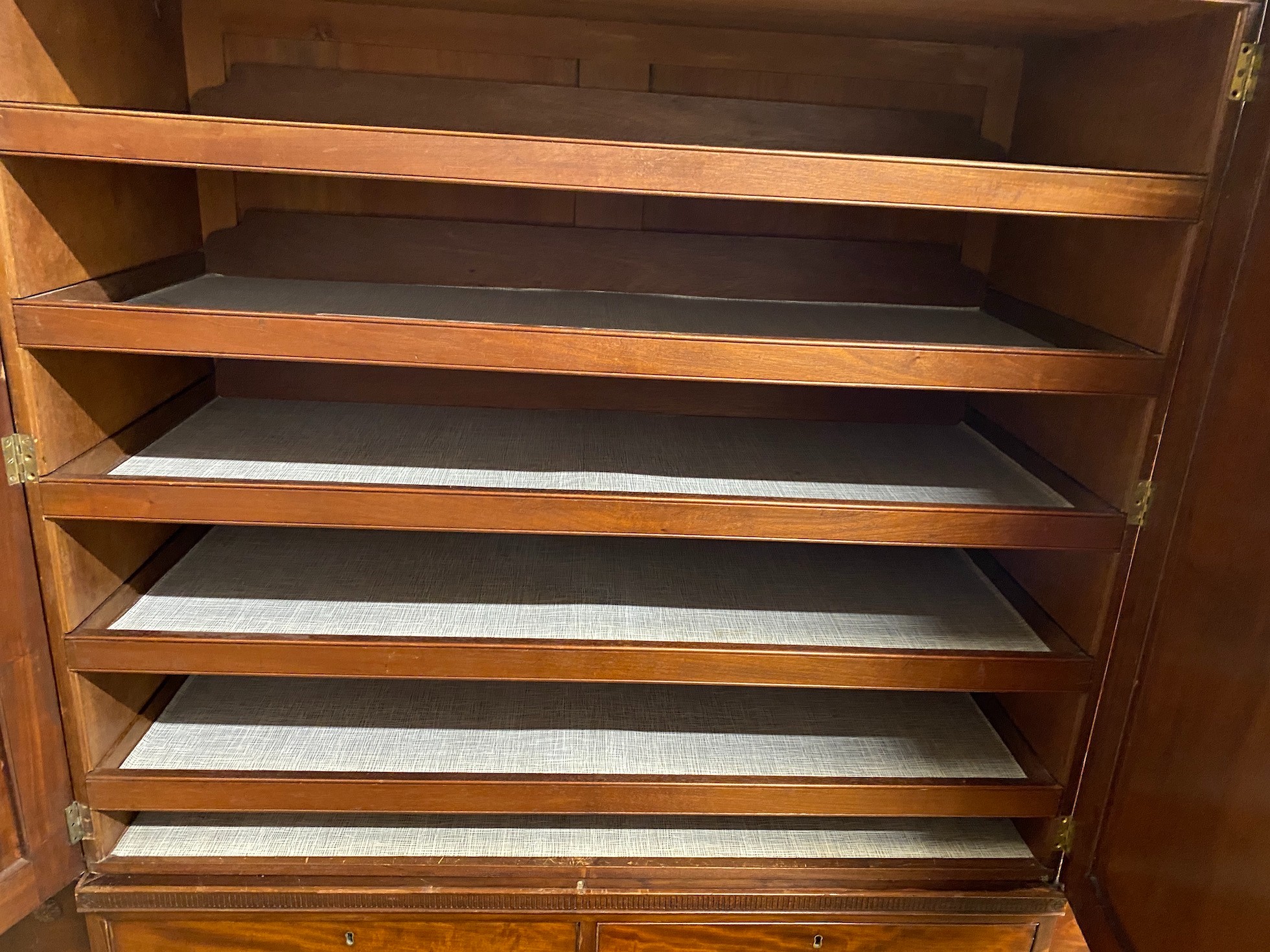 An Edwardian mahogany breakfront wardrobe, with two doors enclosing trays and four drawers flanked by hanging compartments, width 256cm, height 209cm